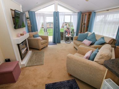 A living room with a television and a fireplace at Gentle Tide Hasguard Cross near Little Haven