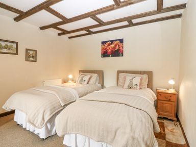 A bedroom with two single beds and bedside tables at Loanview in Cornhill-On-Tweed