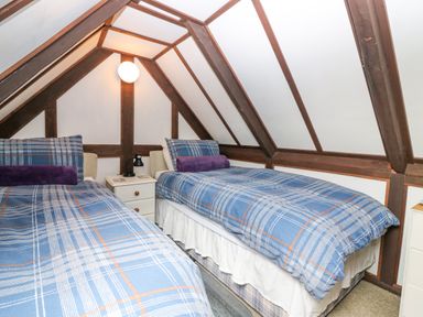 A bedroom with two single beds and a nightstand at Loanview in Cornhill-On-Tweed