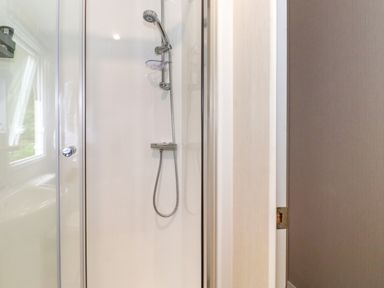 A shower enclosure with a handheld showerhead in a bathroom at Eltons Escape Pony Meadow 3 White Cross Bay near Windermere