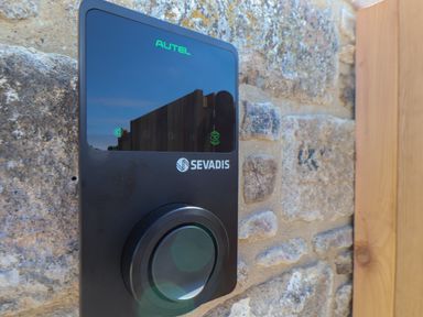 A black Sevadis device mounted on a stone wall with a wooden door frame visible at Victory View in Pendeen