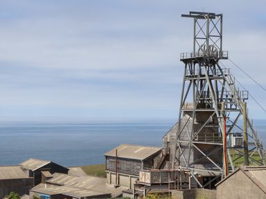An industrial mining structure with buildings near a coastline at Victory View in Pendeen