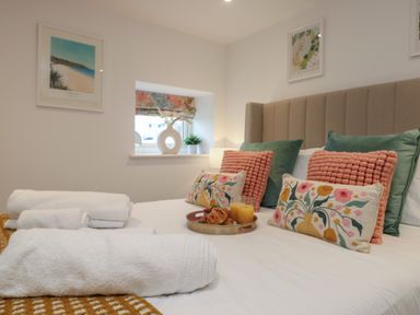 A bedroom with a bed with towels and breakfast on a tray at Victory View in Pendeen