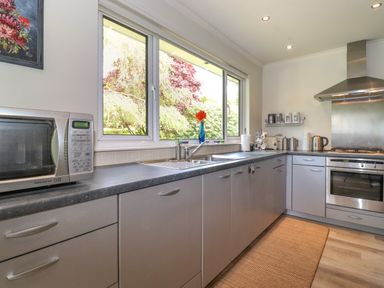 A kitchen with a microwave oven sink stove and cabinets at Sweden Bridge Cottage Ambleside