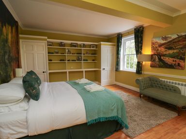 A bedroom with a bed table and chairs at Llwynderw Hall in Abergwesyn near Llanwrtyd Wells