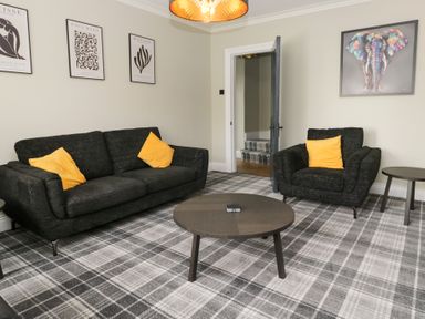 A living room with a sofa and armchair at 5 Thornbarrow Road