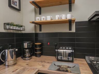 A kitchen area with a kettle, coffee maker, and toaster at 5 Thornbarrow Road