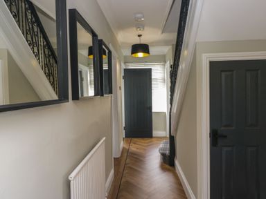 A hallway with stairs and mirrors at 5 Thornbarrow Road