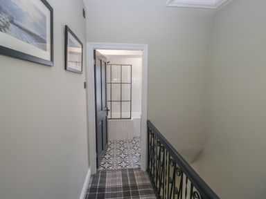A hallway with a door leading to a bathroom at 5 Thornbarrow Road