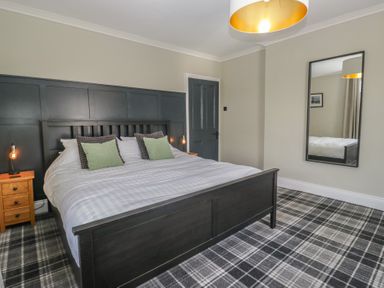 A bedroom with a bed and bedside tables at 5 Thornbarrow Road