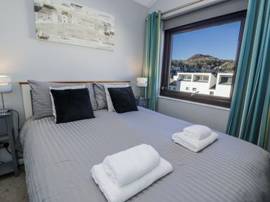 A bedroom with a bed and window view at Estuary Escape in Porthmadog