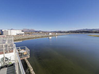 A view of a river with buildings and mountains at Estuary Escape in Porthmadog