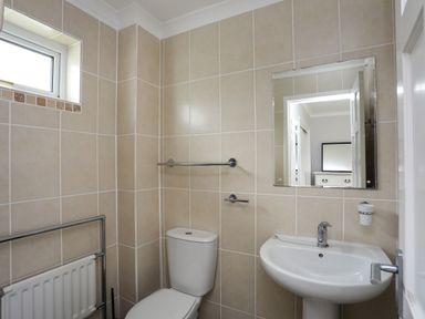 A bathroom with a toilet a sink and a mirror at Mor Glas in Abersoch