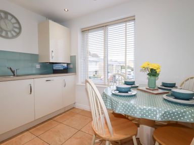 A kitchen with a table and chairs at Blissful Ocean Breeze in Perranporth