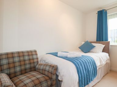 A bedroom with a single bed and a chair at Blissful Ocean Breeze in Perranporth