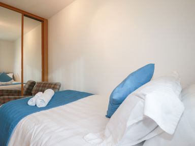A bedroom with a bed and armchair at Blissful Ocean Breeze in Perranporth