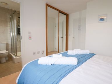 A bedroom with a bed and towels on top at Blissful Ocean Breeze in Perranporth