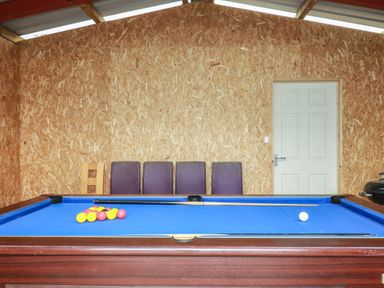 A game room with a pool table and chairs at Lake View in Kestle Mill near Quintrell Downs