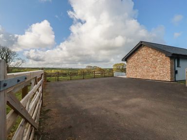 An outdoor area with a house and gate at Lake View in Kestle Mill near Quintrell Downs