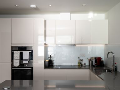 A modern kitchen with built in oven stovetop kettle coffee machine and sink at Apartment 17 Abbey Sands in Torquay
