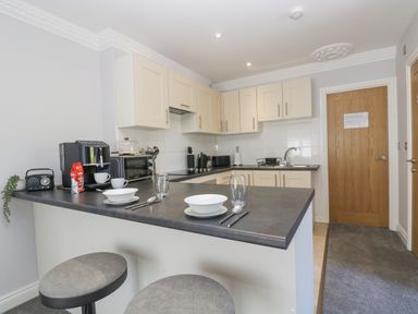 A kitchen with a counter set with bowls glasses and cutlery at Lake View in Swanpool Nr Falmouth