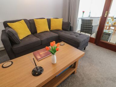A living room with a sofa and a coffee table at Lake View, Swanpool, Nr Falmouth