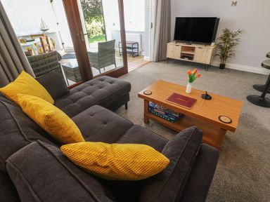 A living room with a sofa and coffee table at Lake View, Swanpool, Nr Falmouth