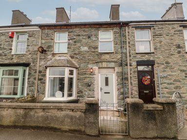 Stone facade terrace houses with bay windows and front gates at 1 Mona Terrace in Llanfachraeth