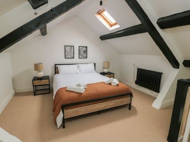 A bedroom with a double bed with two bedside tables and lamps under a skylight at 1 Mona Terrace in Llanfachraeth