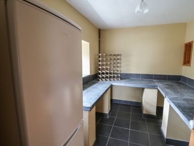 A utility room with a refrigerator wine rack and stone countertops at Castell Y Garn near Newport Beach Pembrokeshire