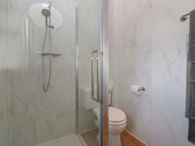 A bathroom with a shower area and a toilet at Doubletree Cottage Swainsford near Mere