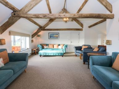 A living room with seating and a painting at Yr Hen Felin in Dyffryn Ardudwy