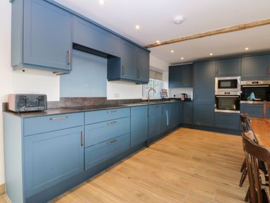 A kitchen with blue cabinets and appliances at Yr Hen Felin Dyffryn Ardudwy