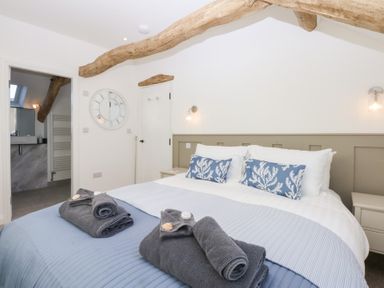 A bedroom with a bed and towels at Yr Hen Felin Dyffryn Ardudwy