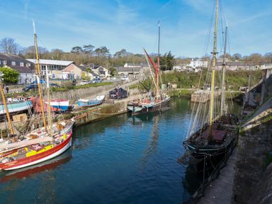 A harbor with several docked sailboats and buildings in the background at 20 Keay Heights in St Austell