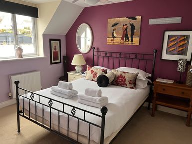 A bedroom with a metal bed and artwork at 20 Keay Heights St Austell