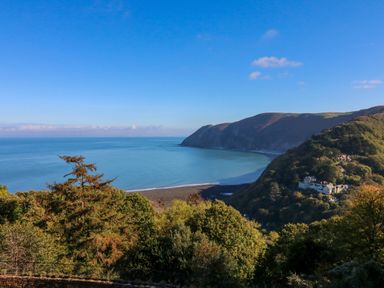 A coastal landscape with trees hills cliffs and ocean at The Old Smithy in Lynton