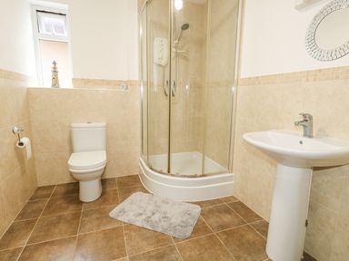 A bathroom with a toilet sink and corner shower enclosure at Dotties Retreat in Weymouth