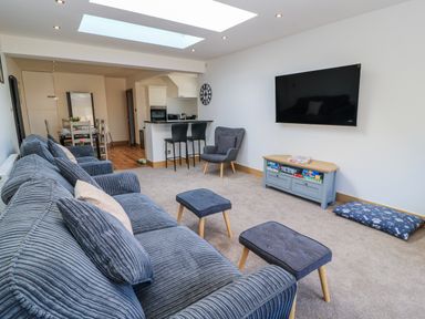 A living room with a television and sofa at The Swanage Rail Lookout in Swanage