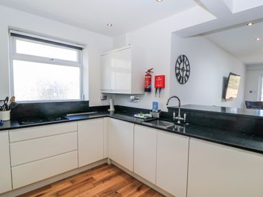 A kitchen with a sink and cabinets at The Swanage Rail Lookout in Swanage