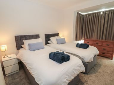 A bedroom with two single beds and a dresser at The Swanage Rail Lookout in Swanage