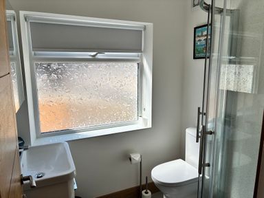 A bathroom with a toilet, sink, and shower at The Swanage Rail Lookout in Swanage