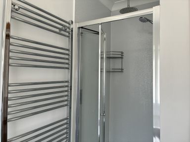 A bathroom with a shower and towel warmer at The Swanage Rail Lookout in Swanage