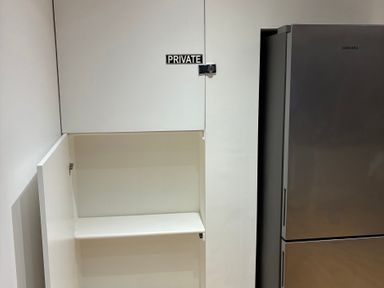 A cabinet and refrigerator in a kitchen at The Swanage Rail Lookout in Swanage