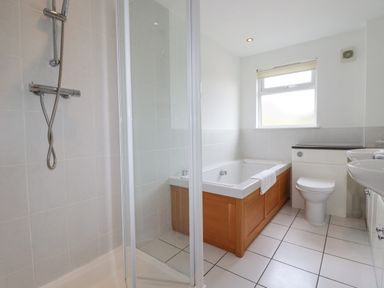 A bathroom with a shower enclosure bathtub toilet and two sinks at The Willows Winnards Perch near St Columb Major