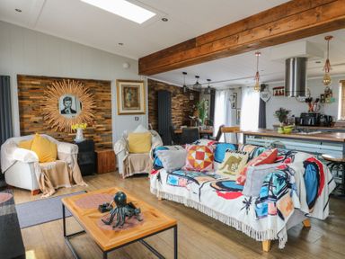 A living room with a sofa and coffee table at Coogee View in Maenygroes near New Quay