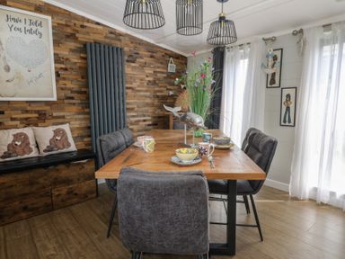 A dining room with a large table and chairs at Coogee View in Maenygroes near New Quay