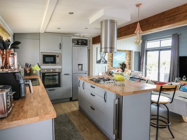 A kitchen with an island and appliances at Coogee View in Maenygroes near New Quay