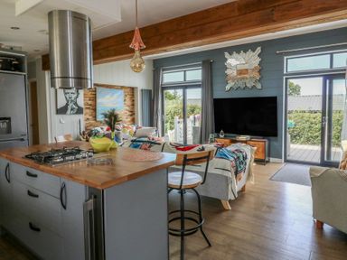A kitchen island with a stove in a living room at Coogee View in Maenygroes near New Quay