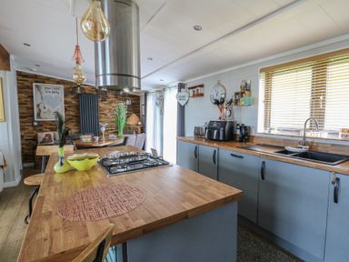 A kitchen with a stove, sink and refrigerator at Coogee View in Maenygroes near New Quay